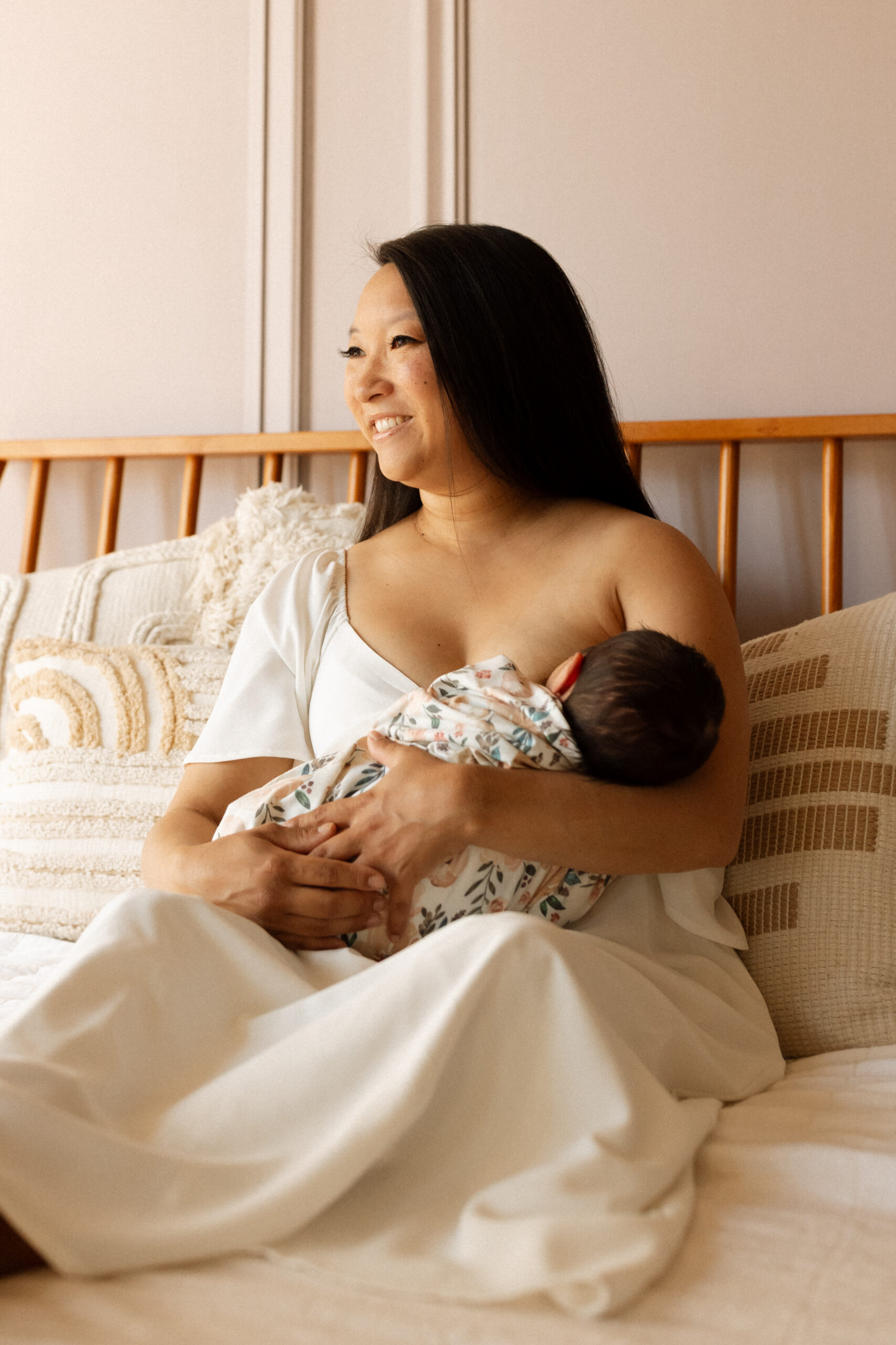 Mother holding her newborn during a relaxed in-home newborn photography session in Seattle.