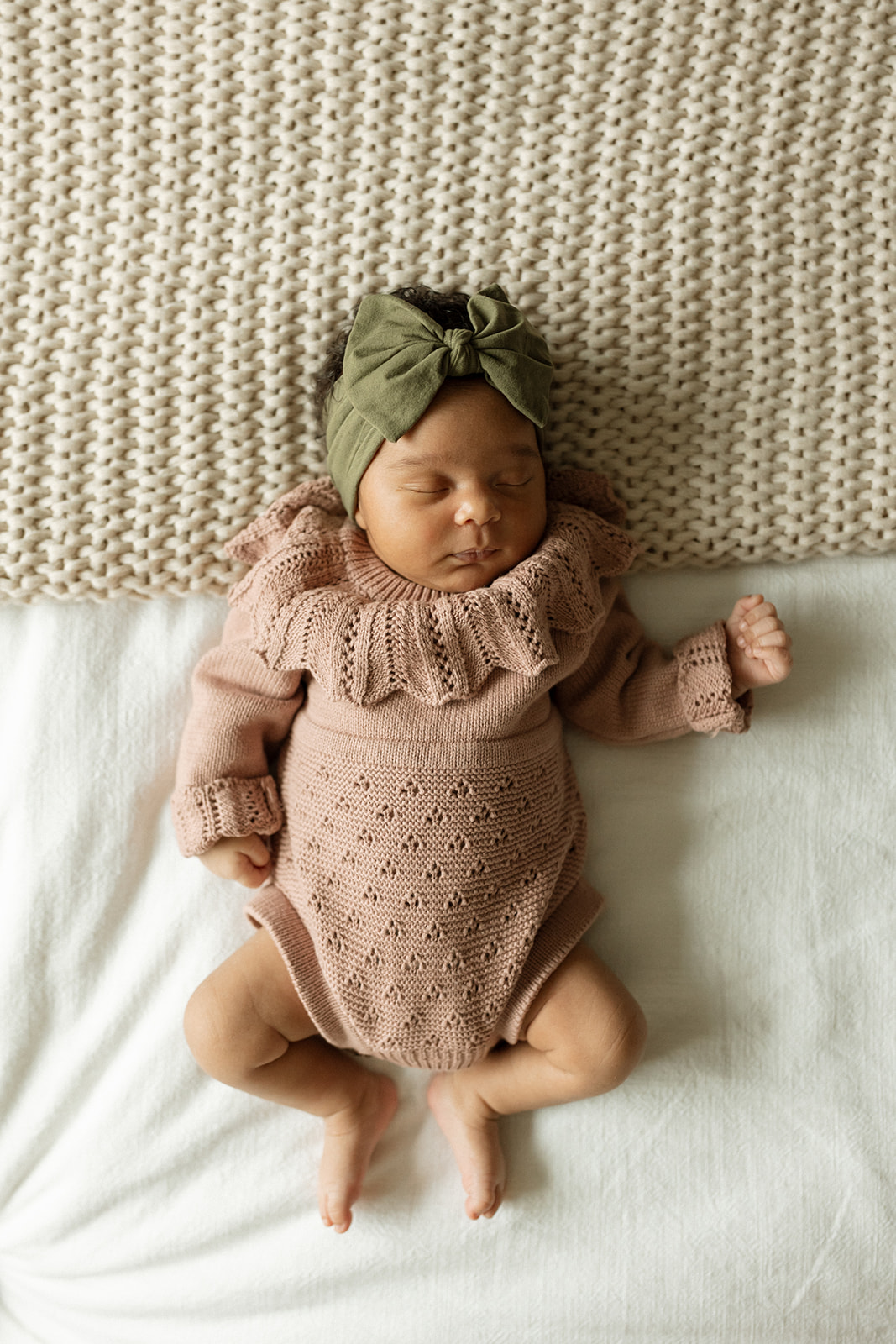 Newborn baby sleeping peacefully in a knit outfit during a Seattle newborn photography session.