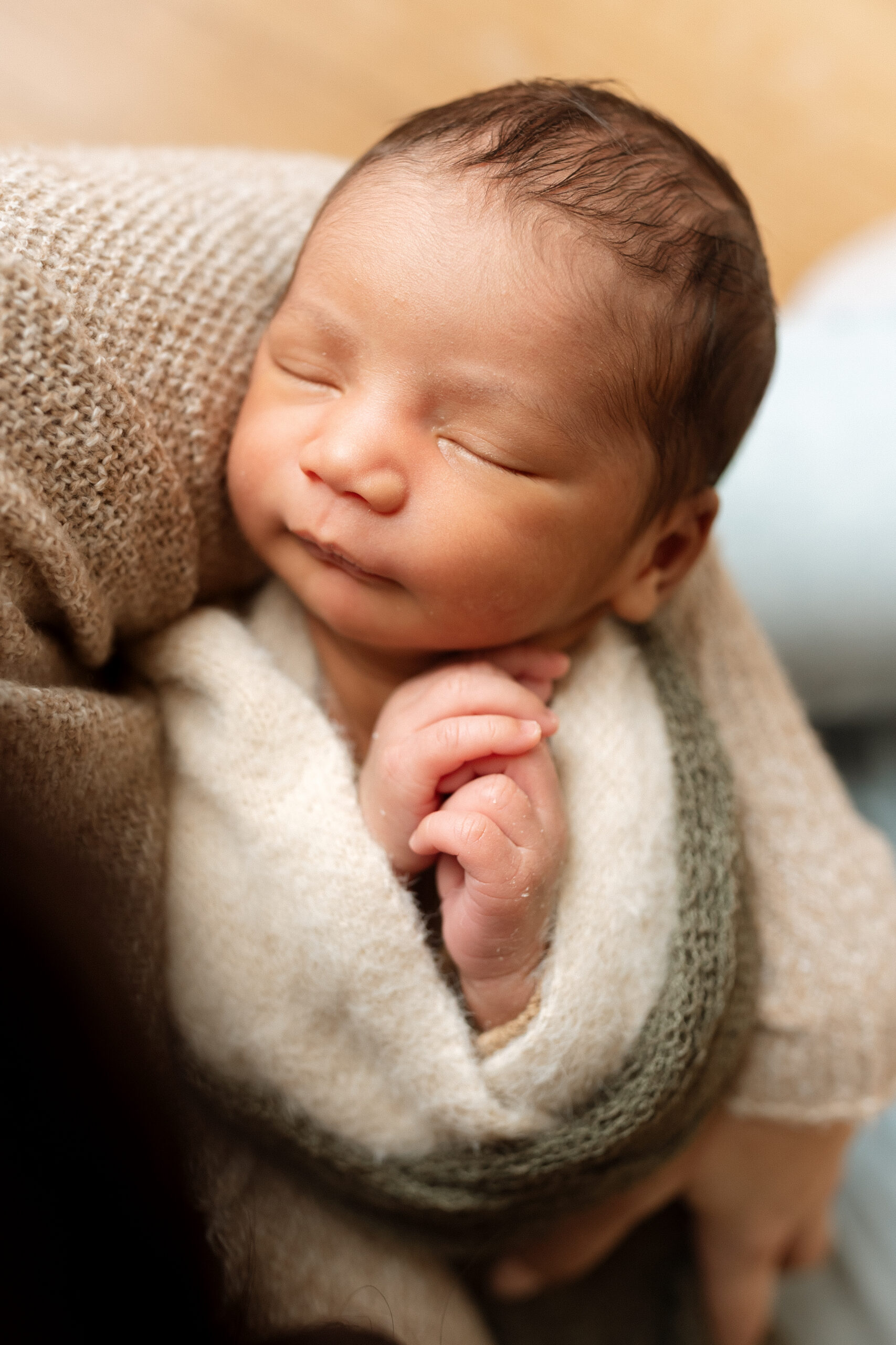 Close-up portrait of a sleeping newborn wrapped in a soft blanket during a Seattle newborn photography session.